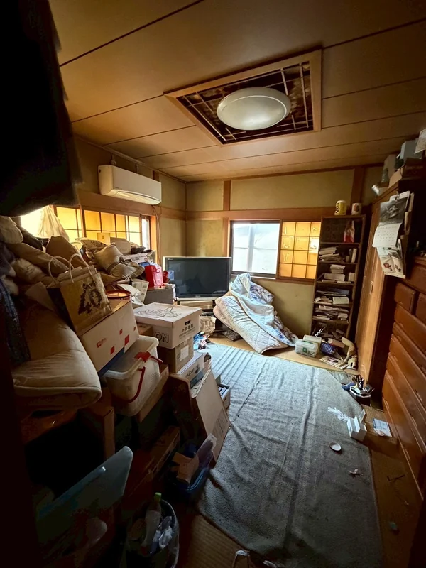 和室の片付け前。布団・家具・家電が散乱